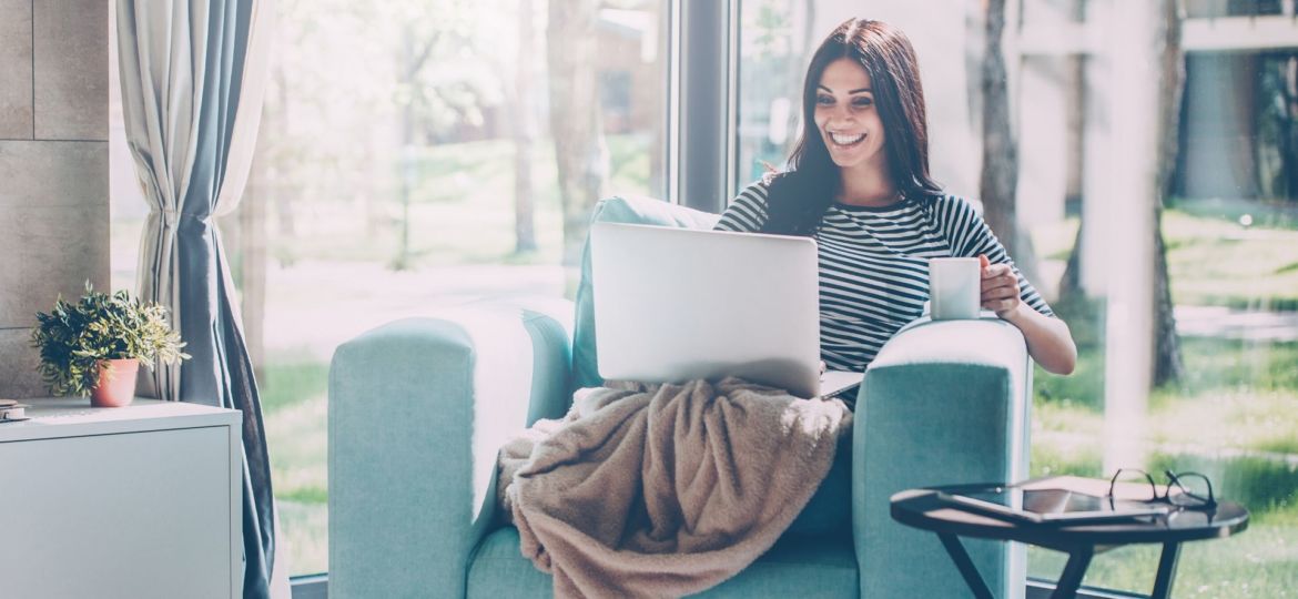 woman staying at home on laptop smiling