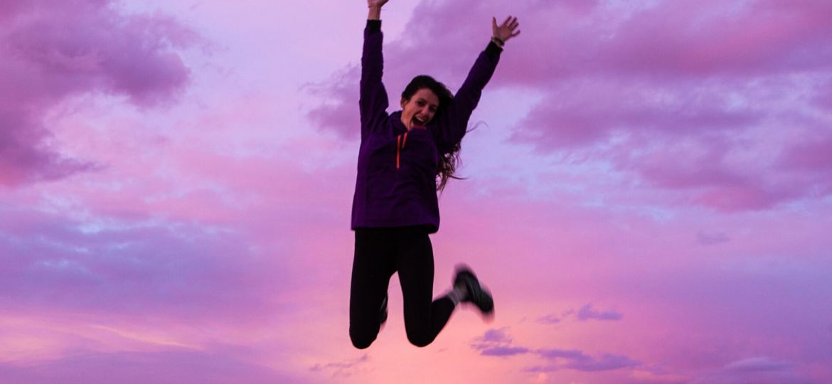 woman jumping in pink clouds