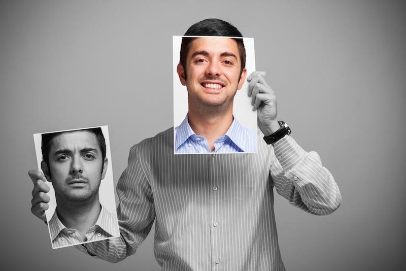 man holding up faces with different moods